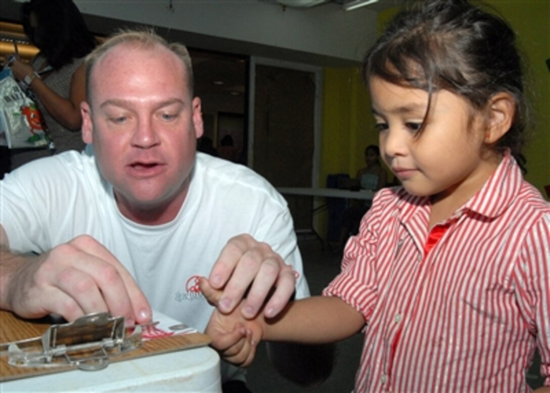 U.S. Navy Petty Officer 1st Class Daniel Jones fingerprints a girl during the 11th annual Project Kid Care event in Agana, Guam, Oct. 28, 2006.