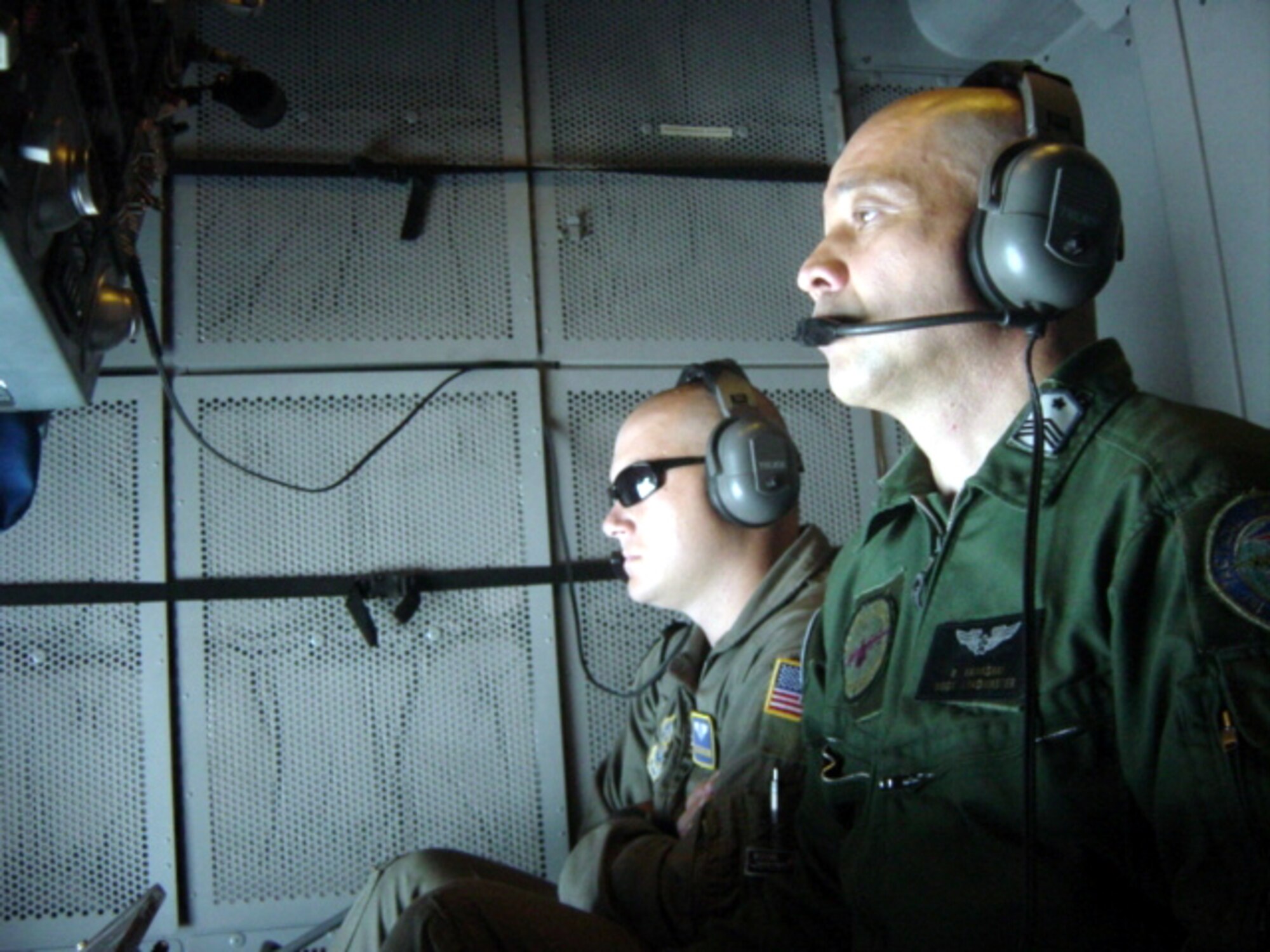 Staff Sgt. Zach Fleming [left], 6th Aerial Refueling Squadron instructor, watches as Master Sgt. Randy Kawasaki, Japan Air Self Defense Force, attempts aerial  refueling contact during a KC-10 training mission. (U.S. Air Force photo)
