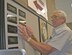 (Ret.) Technical Sgt. Ebert Bailey places the names plates on the volunteer wall memorial in preparation for the unveiling by the wing commander held Oct. 27.  The memorial is located in the main lobby of the base exchange and in front of the satellite pharmacy. (U.S. Air Force photo by Robin DeMark)          