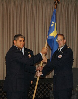 Peterson AFB, Colo. -- Col. Manuel Hidalgo, 21st Mission Support Group commander, passes the 21st Services Squadron guidon to the new squadron commander, Maj. Michael Marvich Oct. 31 at the Team Pete Club. (U.S. Air Force photo by Senior Airman Jessica Switzer.)