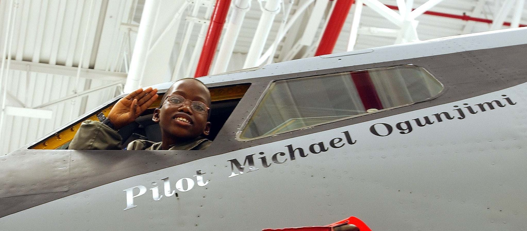 ANDREWS AIR FORCE BASE, Md. -- Michael Ogunjimi, 10, of Washington, D.C., salutes from the cockpit of a Air Force Reserve Command KC-135 Stratotanker Oct. 27. The 459th Air Refueling Wing and the District of Columbia Air National Guard 113th Wing teamed up to host the "Pilot for a Day" program. "P4D" is a community outreach program that allows military and civilian children of all ages who suffer from serious or chronic medical conditions to visit an installation for the day to tour wing and base facilities. (U.S. Air Force photo by Staff Sgt. Amaani Lyle)