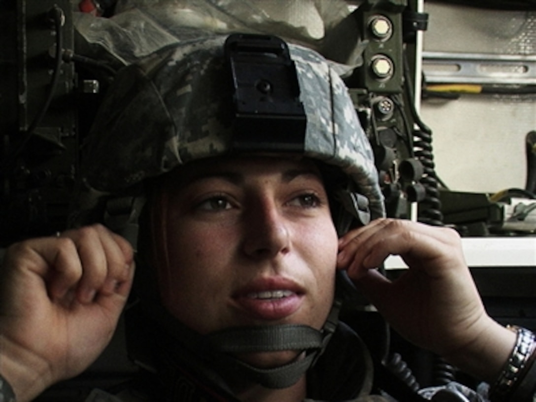 U.S. Army Sgt. Katherine Tripp, with 982nd Signal Company, tightens her helmet on Forward Operating Base Marez, Iraq, Oct. 22, 2006, as she prepares to go on mission in a Stryker with soldiers from Bravo Company, 2nd Battalion, 3rd Infantry Regiment, Fort Lewis, Wash. 