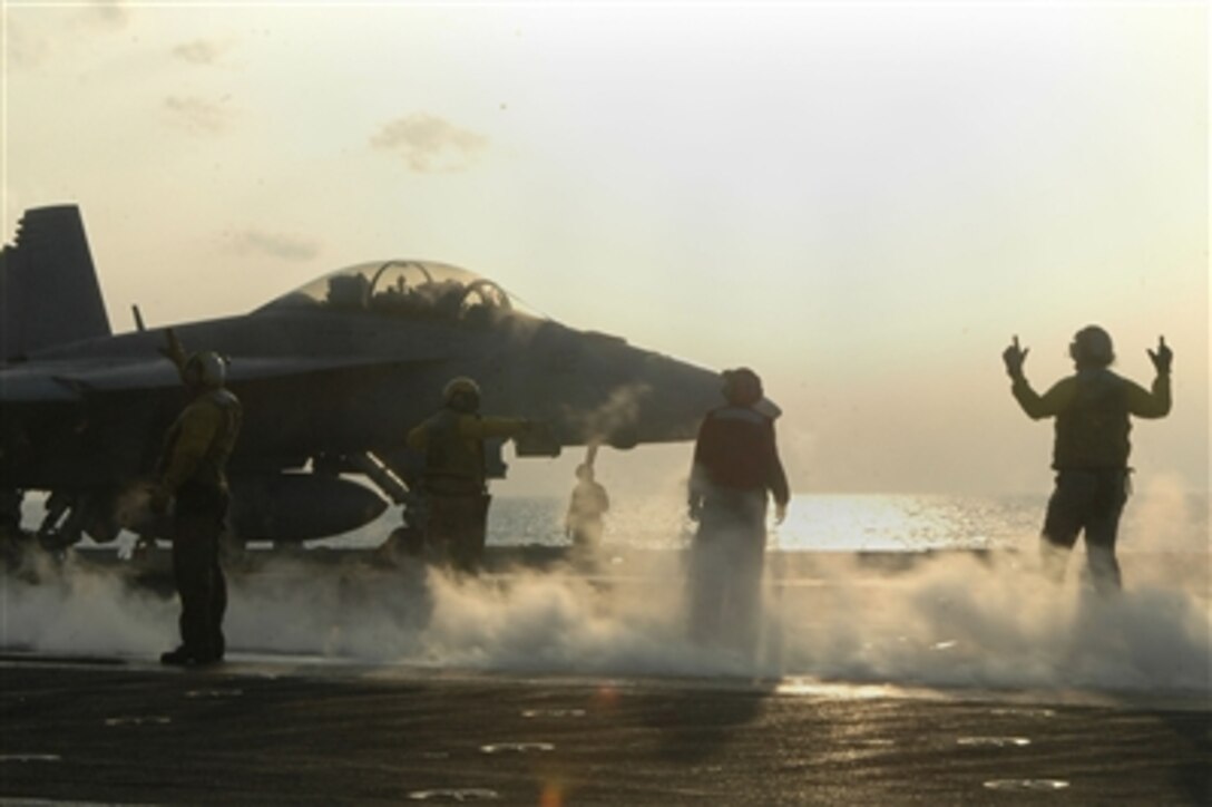U.S. Navy aircraft directors signal an F/A-18F Super Hornet aircraft from Strike Fighter Squadron 102 onto catapult No. 3 in preparation for evening flight operations on the flight deck of USS Kitty Hawk, Oct. 24, 2006. Kitty Hawk operates out of Fleet Activities Yokosuka, Japan. 