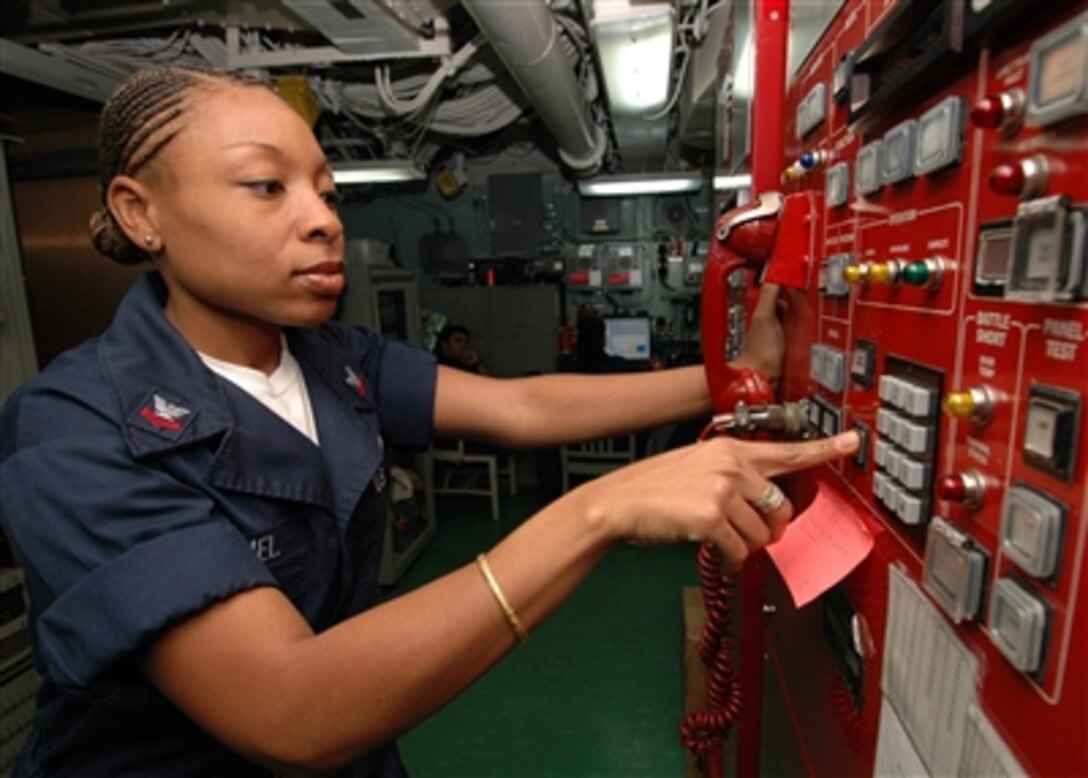 Navy Petty Officer 2nd Class Hendra Samuel works on the signal audio system in the joint message center aboard the USS Iwo Jima (LHD 7) on Oct 23, 2006.  Samuel is a Navy information system technician stationed onboard the Iwo Jima.  