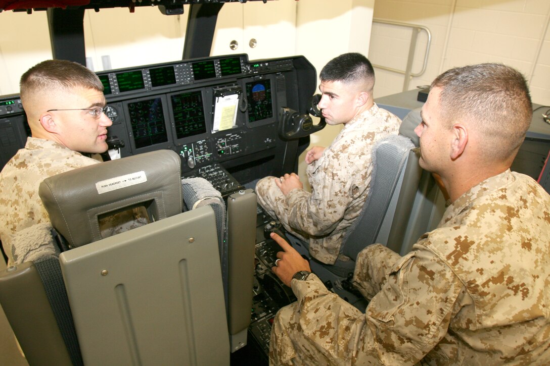 Sgt. Joshua Robertson instructs Lance Cpl. Chad D. Dunn and Lance Cpl. Isaiah D. Ybarra in the cockpit avionics trainer. Robertson, Dunn and Ybarra are C-130J crew chiefs.