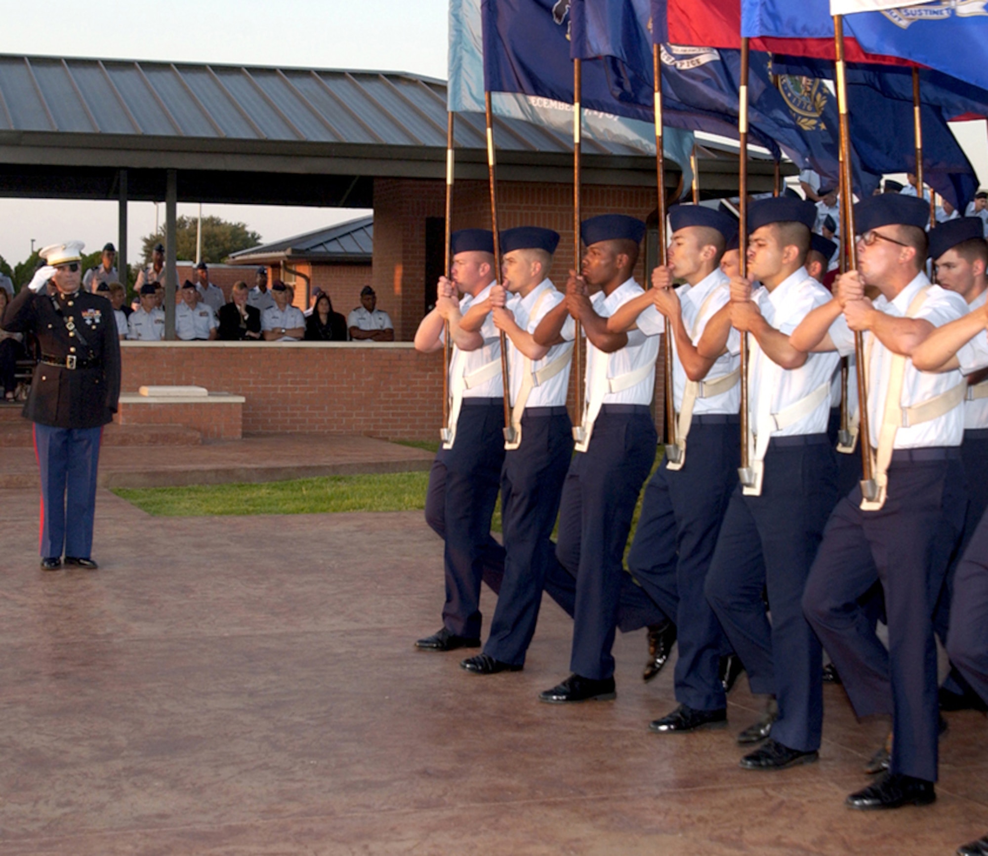 Retired Marine Lt. Clebe McClary, a Vietnam Veteran, salutes the state flags of the United States during a POW/MIA Day parade at the base parade grounds.  (U.S. Air Force photo/Sandy Wassenmiller)