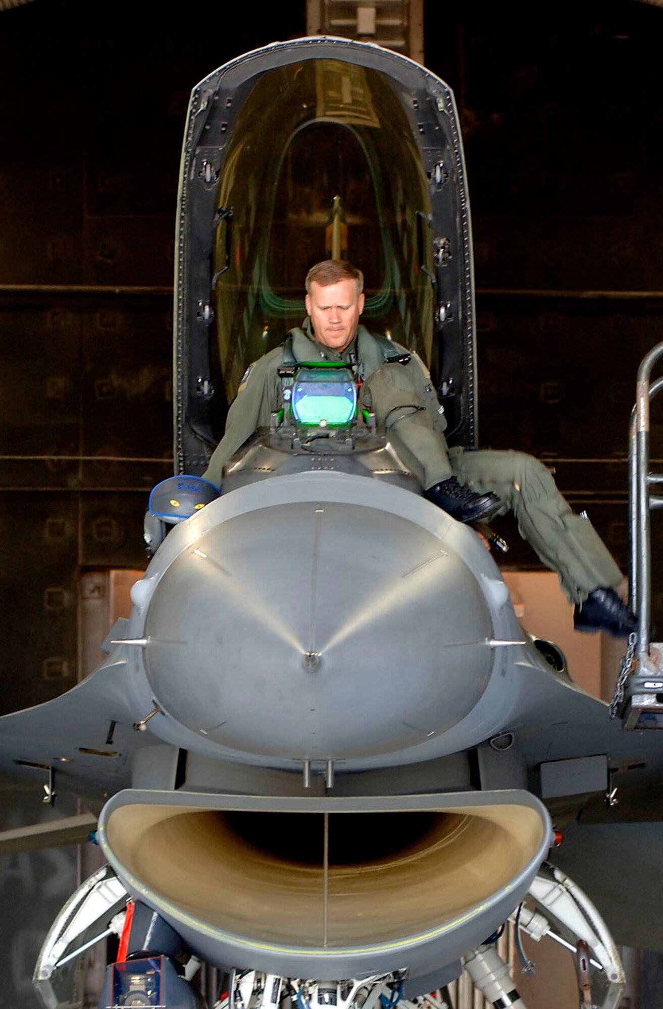 Colonel Jeffrey Lofgren, 8th Fighter Wing commander, steps off a platform and eases in the cockpit of an F-16 Fighting Falcon at Kunsan Air Base, South Korea. (U.S. Air Force photo/Daren Reehl)