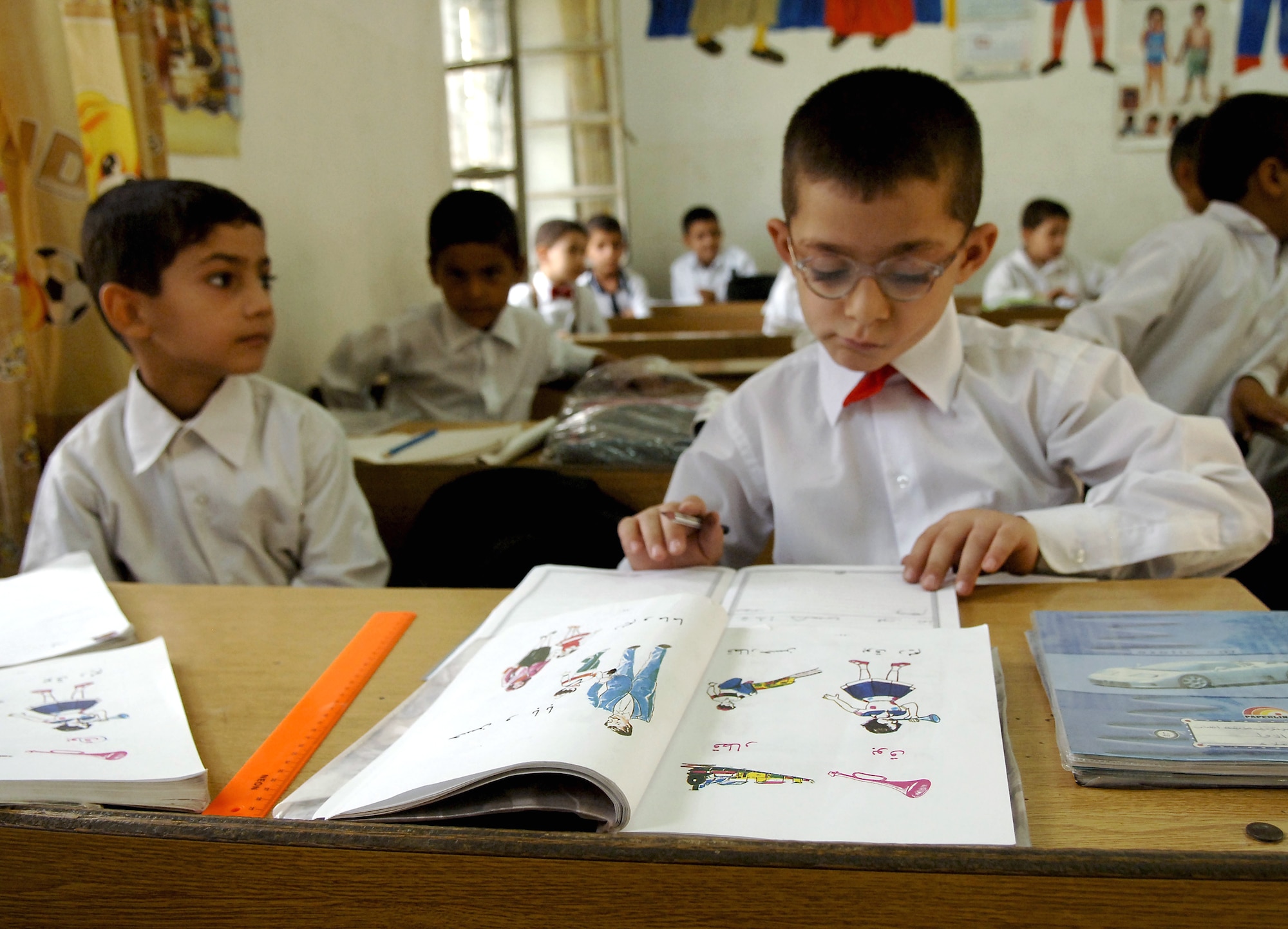 A young Iraqi boy looks over his lessons at a primary school in the Bayaa District of Baghdad, Iraq, Oct. 31. (U.S. Air Force photo/Master Sgt. Mike Buytas)