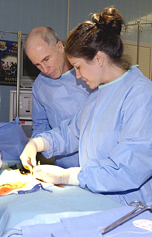Tech. Sgt. Dolores Lerschen, an instructor supervisor at the 383rd Training Squadron's Surgical Services Apprentice Course, helps Brig. Gen. Richard Devereaux during an "appendectomy" Sept. 14. (U.S. Air Force photo/Harry Tonemah)