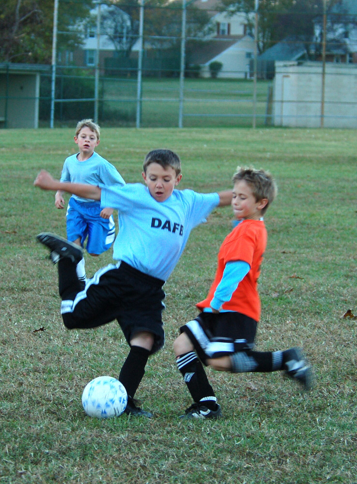 DOVER AIR FORCE BASE, Del. -- (Left to right) Mike Chappo, Dover Air Force Base Youth Center Tigers, dribbles and tries to keep the ball away from Hannah Moon and Jancaeil Drane, DAFB Youth Center Hurricanes. Four teams comprise Dover AFB’s 7- to 8-year-old Youth Center soccer league. The season is nine games long with each team playing the other teams three times. The teams are coached and refereed by volunteers from the base. (U.S. Air Force photo/Staff Sgt. James Wilkinson)

Photos by Staff Sgt. Jim Wilkinson
(Continued Page 12) Caleb Hellman and Blake Lundeen, tackle the ball during their recent match up.
