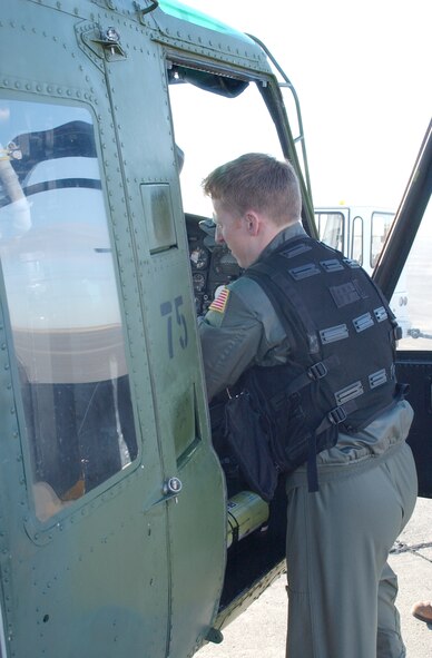 Capt. Marc Milligan, 40th Helicopter Squadron pilot, makes some minor adjustments to the seat of the UH-1N helicopter nbefore getting in.