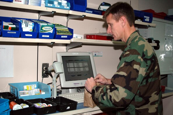 Maj. John Barnett, pharmacist, checks the barcode on a prescription for accuracy.