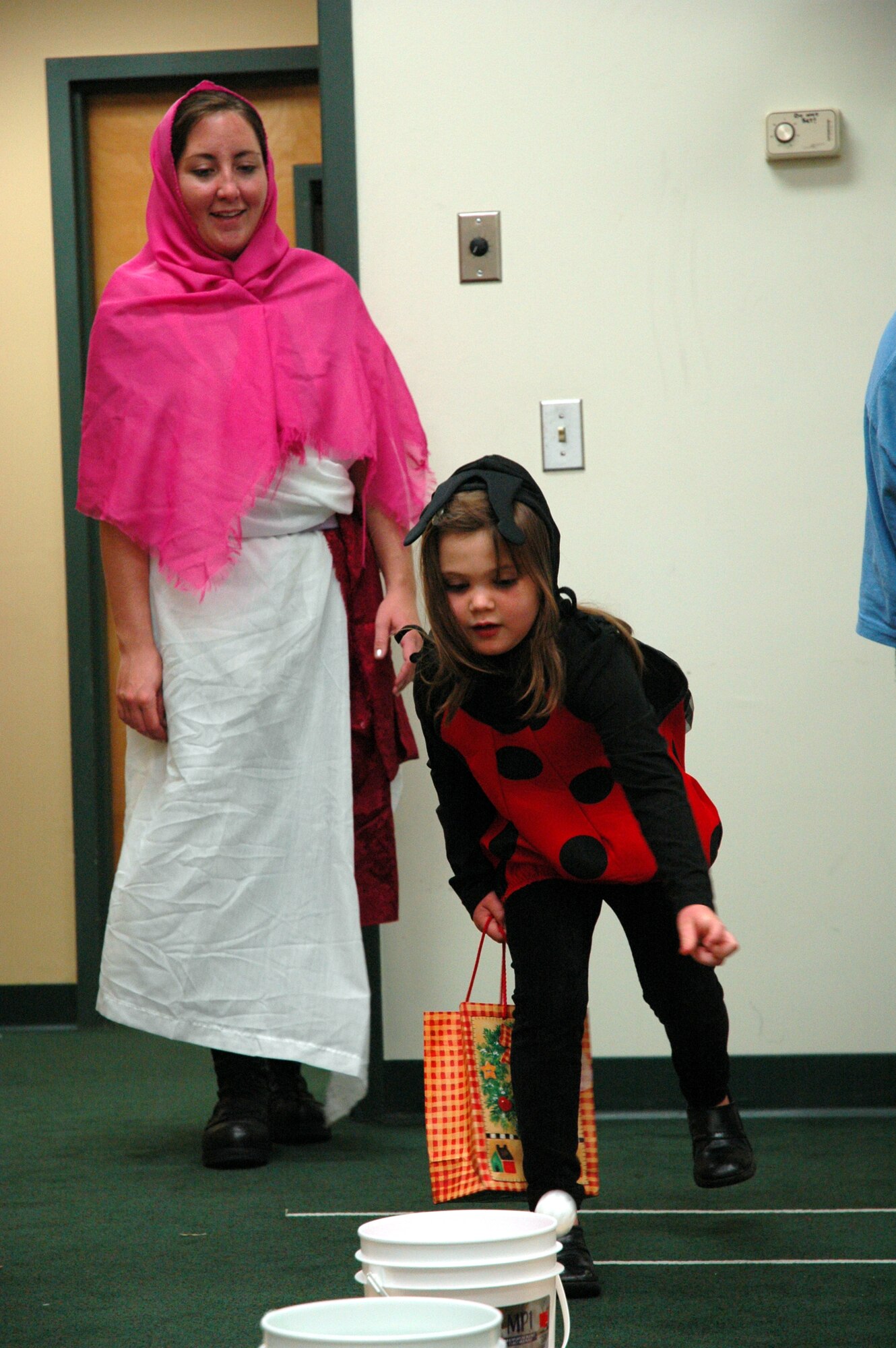 A little lady bug tosses a ping pong ball into a bucket during the Fall Festival. The chapel offered a different alternative to trick-or-treating. (U.S. Air Force Photograph by 2nd Lt. Lauren Johnson)
