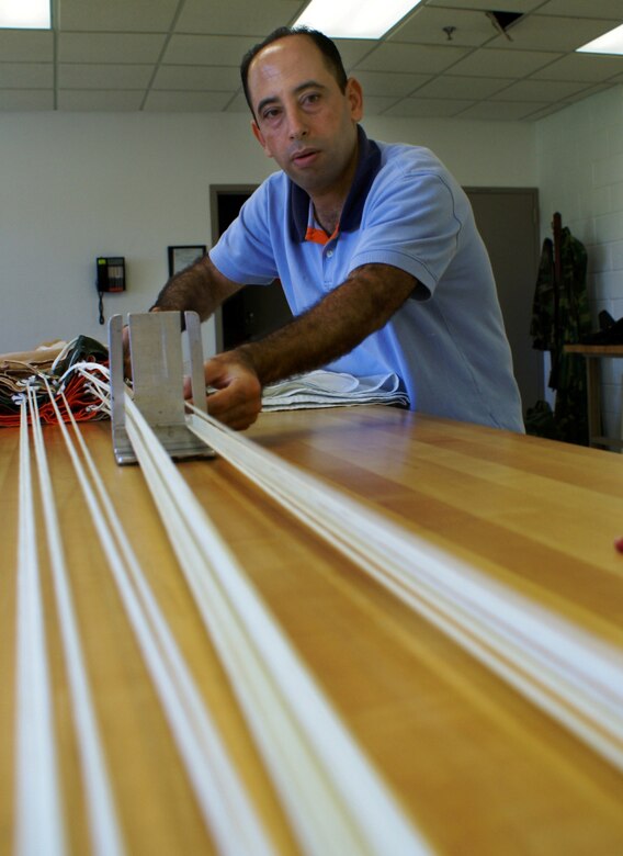 Khalid Bensitel, an Air Reserve Technician and Senior Airman in the Air Force Reserve, aligns 550-pound strength parachute cords as he prepares the chute for packing. Bensitel is a survival equipment specialist here at Homestead Air Reserve Base, Fla. (Air Force photo by Dan Galindo)