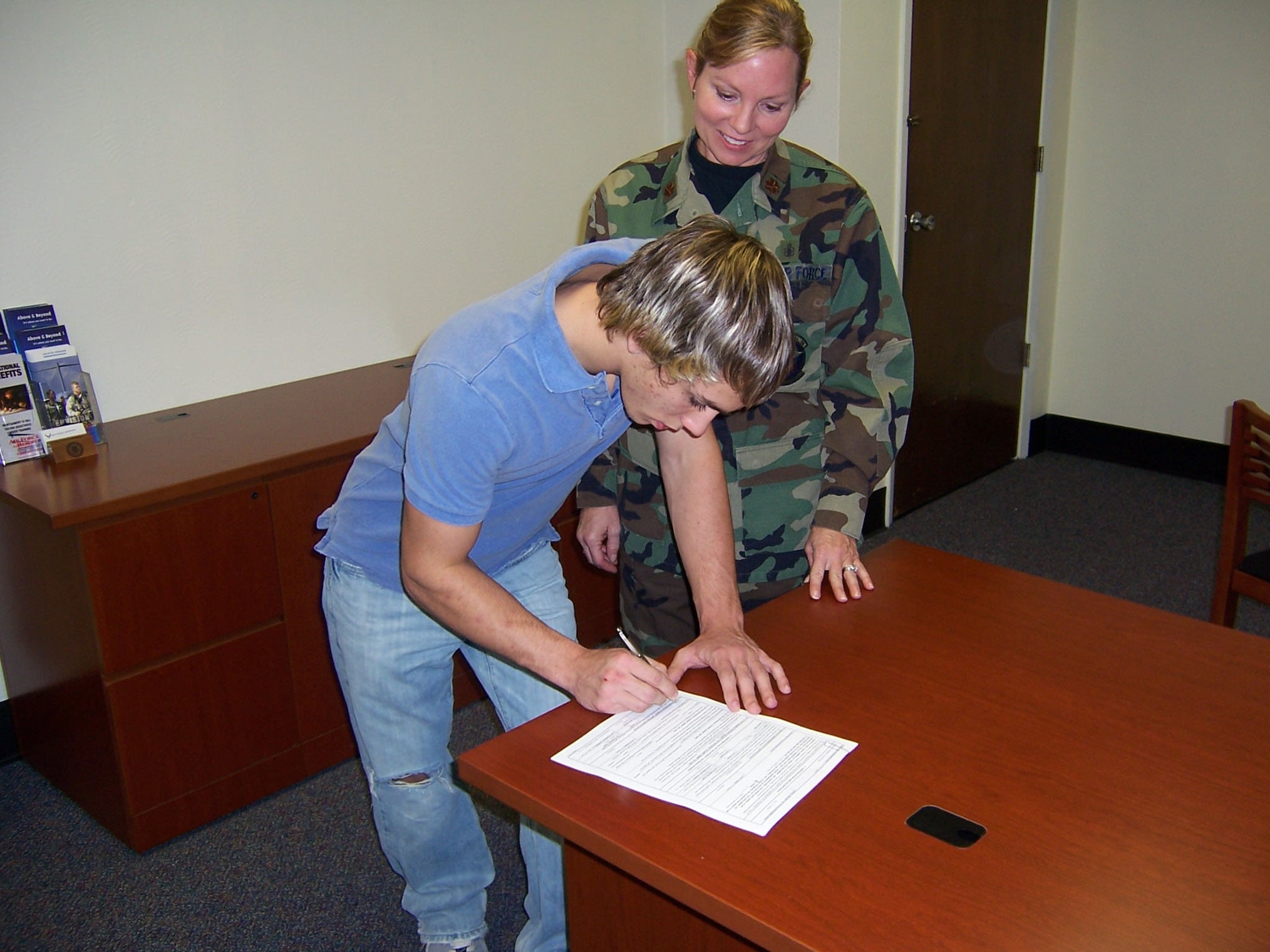 Josh Amburn signs his enlistment paperwork while his mother, Maj. Susan Geer looks on. Josh enlisted in the Air Force Reserve (sworn in by his mother), and more specifically the 717th Aircraft Maintenance Squadron, Monday, Oct. 23, at the recruiting station on Mansfield Road in Shreveport, La. Major Geer is a member of the 917th Wing. (U.S. Air Force courtesy photo)