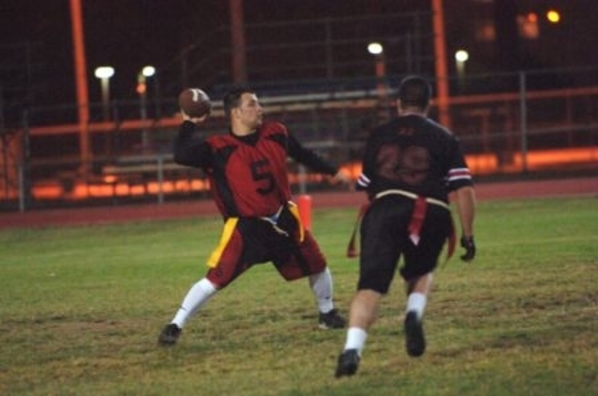 Mike Averill, 728th Air Mobility Squadron quarterback, drops back to pass the ball while under hot pursuit during a regular season flag-football game here. (Courtesy photo)