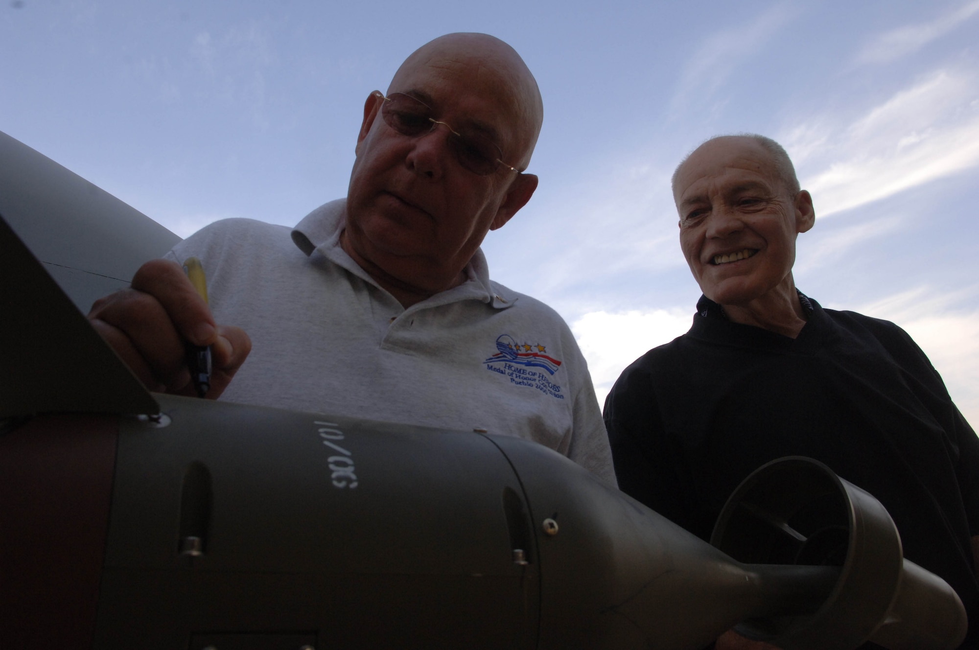 Medal of Honor recipients Gary Littrell (L) and Robert Howard sign a LGB on an A-10 Thunderbolt II aircraft prior to departing on another close air support mission over Afghanistan.  The two were visiting Bagram Airfield as part of an Medal of Honor Society tour to all of the bases in Iraq and Afghanistan.  They spoke with numerous Airmen and Soldiers and thanked them for their efforts fighting the Global War on Terrorism (U.S. Air Force photo/Tech. Sgt. Joseph Kapinos)