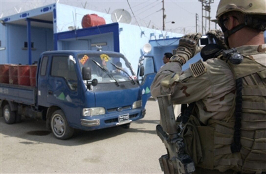 U.S. Navy Petty Officer 1st Class Travis J. Schellpeper, an explosive ordnance technician, takes photographs of a vehicle suspected to be transporting a large cache of explosives in Ad Diwaniyah, Iraq, Oct. 30, 2006.