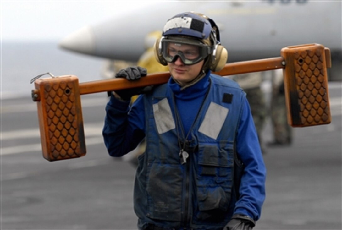 Airman Dustin Savoie moves chocks from an aircraft during flight operations aboard the USS Nimitz  in the Pacific Ocean, Oct. 30. Nimitz is conducting Tailored Ships Training Availability off the coast of Southern California. 