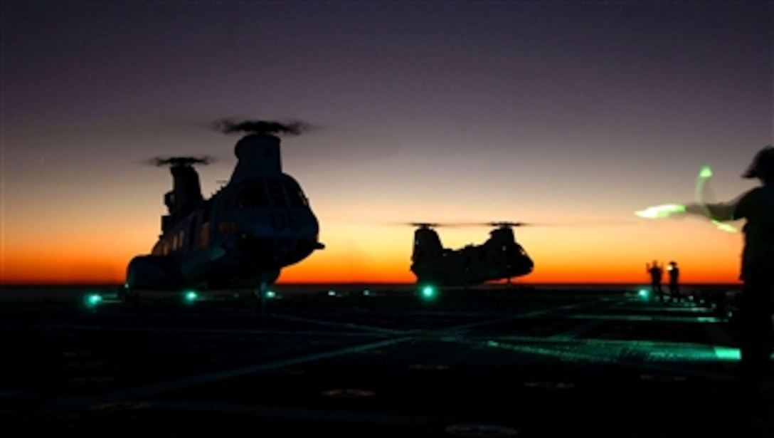 Two CH-46 Sea Knight helicopters land on the flight deck of the amphibious docking ship USS Shreveport (LPD 12) during night operations in the Atlantic Ocean on Oct. 29, 2006.  Shreveport is conducting a component unit exercise in preparation for an upcoming deployment.  