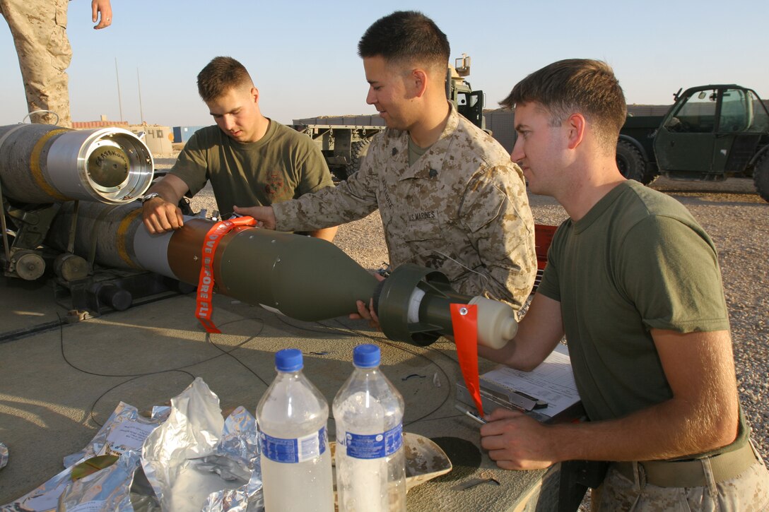 Lance Cpl. John A. Portell (left), Sgt. Alex C. Applegate (center), and Cpl. Joseph G. Johnson attach a guidance system to a GBU-12 bomb at Al Asad, Iraq, Nov. 3. The three aviation ordnance systems technicians with the munitions section of Marine Aviation Logistics Squadron 16, Marine Aircraft Group 16 (Reinforced), 3rd Marine Aircraft Wing (Forward), are responsible for the storage, maintenance and delivery of Marine aviation ordnance in Western Iraq. Portell is a Kirtland, N.M., native. Applegate is a San Diego, native. Johnson is an Eastpointe, Mich., native.