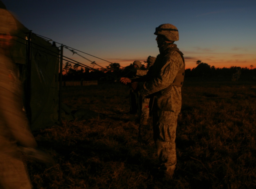 Marines from the 26th Marine Expeditionary Unit's Combat Logistics Battalion-26 build tents to house displaced persons during a humanitarian assistance drill, Nov 4, 2006.  The II Marine Expeditionary Forces Special Operations Training Group graded the CLB-26 on its proficiency in building the camp and managing the affected population who would use the facility after its construction.