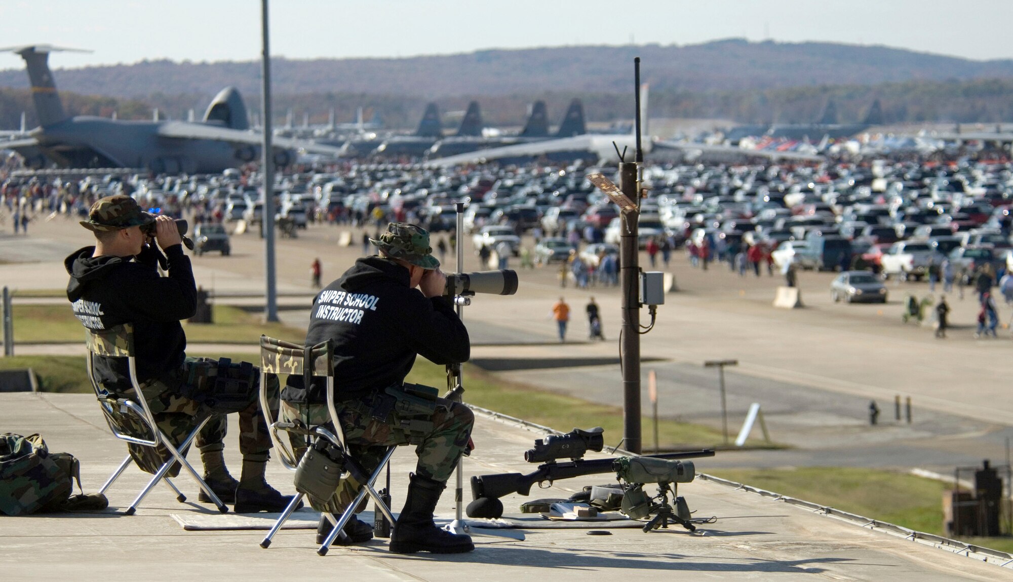 Instructors from the Arkansas Air National Guard's sniper school keep an eye on the crowd from a roof top here November 4, 2006.  The instructors are looking for any activity that might endanger spectators or Air Force resources.  (U.S. Air Force Photo/Master Sgt Jack Braden)