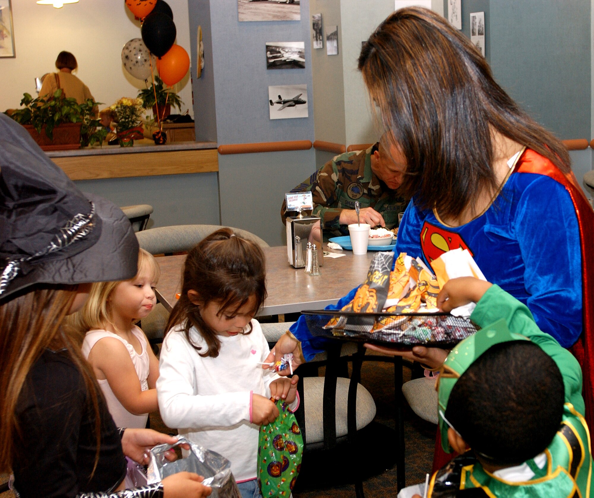 Tech. Sgt. Sheila White, 30th Mission Support Squadron, passes out candy to children at the Deployed Spouses Halloween Costume Party Oct. 26 at the Breakers Dinning Facility here. The party was sponsored by the Family Support Center and the 30th Services Division to help keep moral high and bring the families of deployed Airmen together. (U.S. Air Force photo/Airman Nichelle K. Griffiths)                                