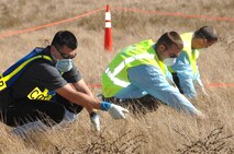 (From right to left) Solano County Coroner Investigator Adrian Garcia and Staff Sgt. Mark Hayes, 60th Aircraft Maintenance Squadron and Master Sgt. Christopher Drumm, 60th Logistics Readiness Squadron, search inch by inch for any item found within the simulated aircraft crash site during Exercise “Aircraft Down,” a joint exercise between Travis Air Force Base, Calif., and the surrounding local community, held Oct. 19.
(Travis AFB, CA, Released)
