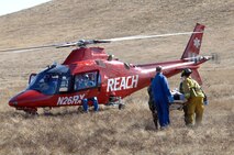 Servicemembers from Travis Air Force Base, Calif. and REACH Helicopter personal airlift "victims" out of a simulated aircraft crash site. Team Travis members, along with the surrounding local communities, participated in Exercise "Aircraft Down" to test their ability to work together during a major crisis. The exercise, the largest exercise in the area since 1998, included more than 32 off-base agencies and 350 people. (Travis AFB, Calif., Released) 