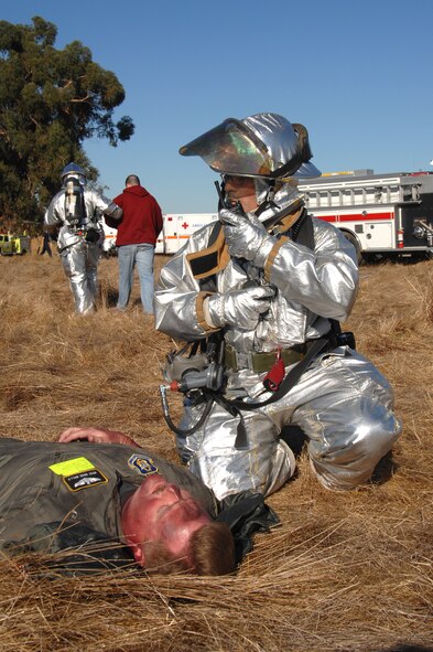 Mr. Marc Renucci, Travis firefighter tends to "victim" Master Sgt. Wade Wells, 70th Air Refueling Squadron, during a simulated aircraft accident. Travis and the local community united to test their teamwork during Exercise "Aircraft Down." More than 90 Travis members volunteered to play "victims" of a C-5 Galaxy crash. The victims were given realistic looking injuries so first responders could hone their emergency response skills. 
(Travis AFB, Calif., Released)