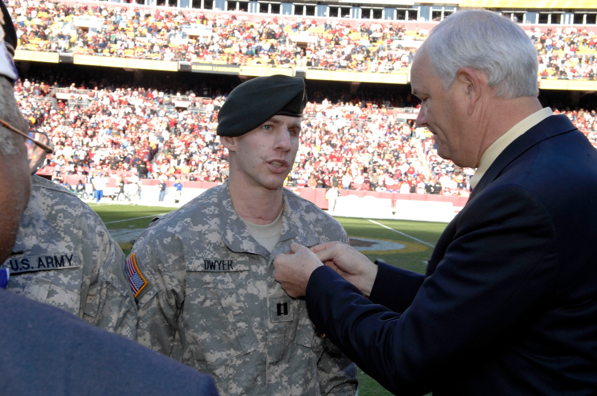 Secretary of the Air Force Michael W. Wynne presents a Purple Heart to Army Capt. Ken Dwyer at Air Force Appreciation Day at FedEx Field in Landover, Md., on Nov. 5.  The presentation took place prior to the National Football League game between the Washington Redskins and the Dallas Cowboys.  Captain Dwyer, of Fort Walton Beach, Fla., served in Afghanistan.  (U.S. Air Force photo/Tech. Sgt. Cohen Young)