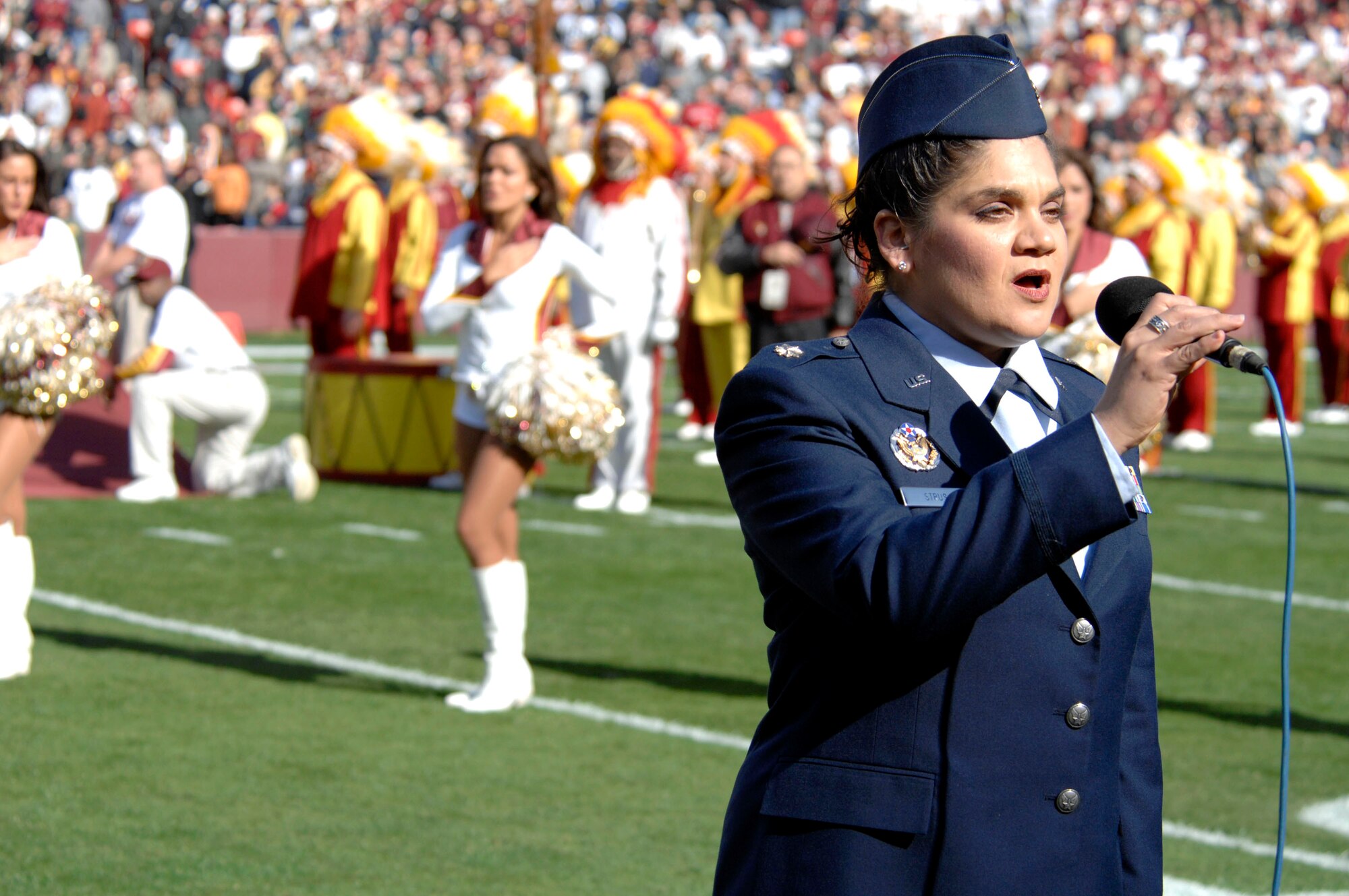 Maj. Kat Strus of the Air Force District of Washington sings the National Anthem during Air Force Appreciation Day at FedEx Field in Landover, Md., on Nov. 5.  As part of the festivities prior to the National Football League game between the Washington Redskins and the Dallas Cowboys, Secretary of the Air Force Michael W. Wynne presented Purple Hearts to two Soldiers and officiated the coin toss. Four F-22 Raptors from Langley Air Force Base, Va., flew over the field during the National Anthem.  (U.S. Air Force photo/Tech. Sgt. Cohen Young)