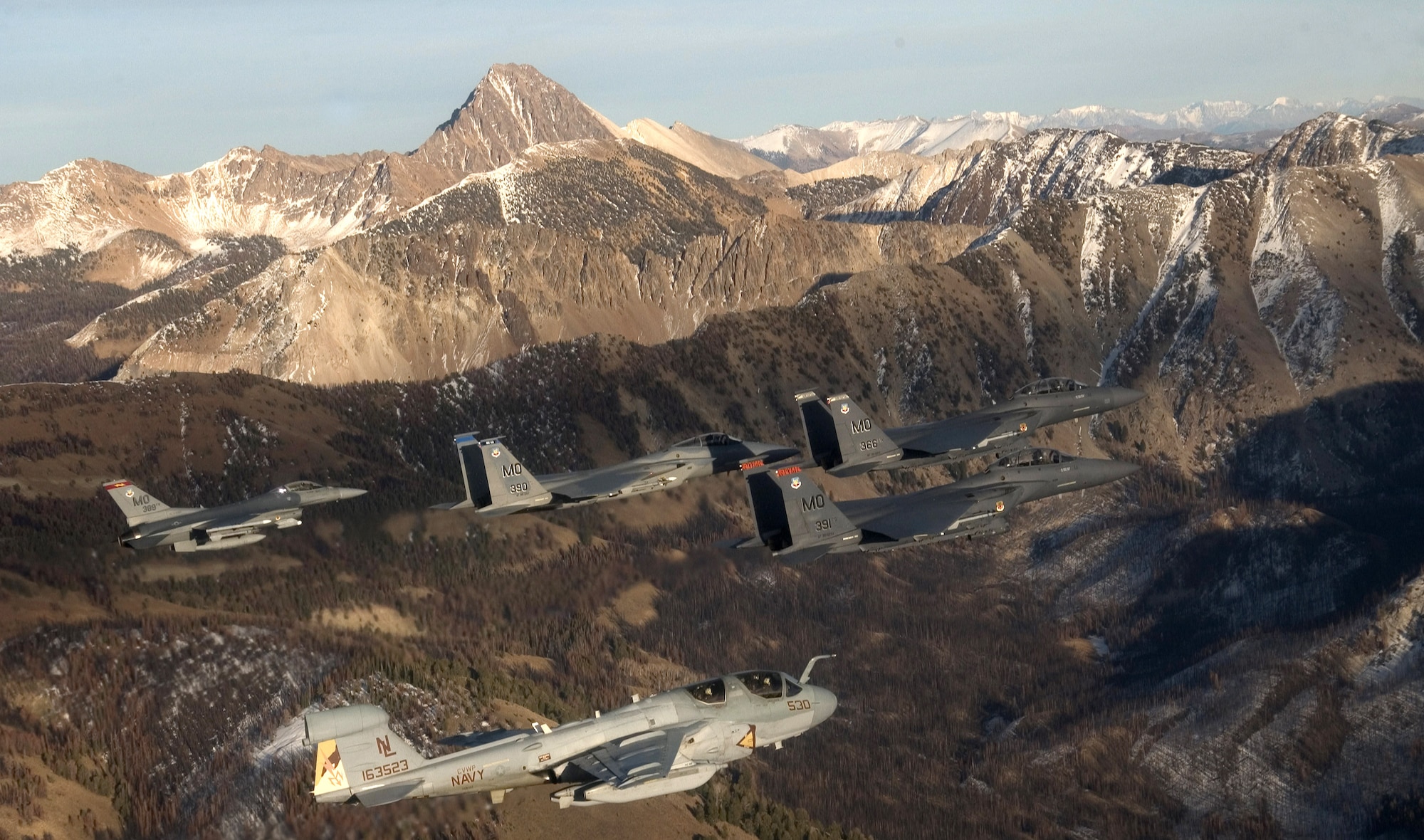 A five-ship formation flies over the Idaho Sawtooth Mountains Nov. 1. Col. Anthony Rock, 366th Fighter Wing commander, led the formation of two F-15E Strike Eagles, and F-15 Eagle, an F-16 Fighting Falcon, all from the 366th FW at Mountain Home Air Force Base, Idaho, and an EA-6B Prowler from the 388th Electronic Control Squadron at Naval Air Station Whidbey Island, Wash., a geographically separated unit from the 366th FW The 366th FW began the first phase of its F-16 drawdown when five jets departed the base Nov. 2. The departure is part of the wing's realignment. The 366th FW began the first phase of its F-16 Fighting Falcon drawdown when five jets departed the base Nov. 2. The departure is part of the wing?s realignment from an F-16, F-15C and F-15E base to an all F-15E Strike Eagle installation by 2011. The move, outlined in the 2005 Base Realignment and Closure recommendation, is also part of the Air Force initiative to become a smarter and leaner force by consolidating its F-15 and F-16 fighter aircraft. (U.S. Air Force photo/Master Sgt. Kevin J. Gruenwald)
