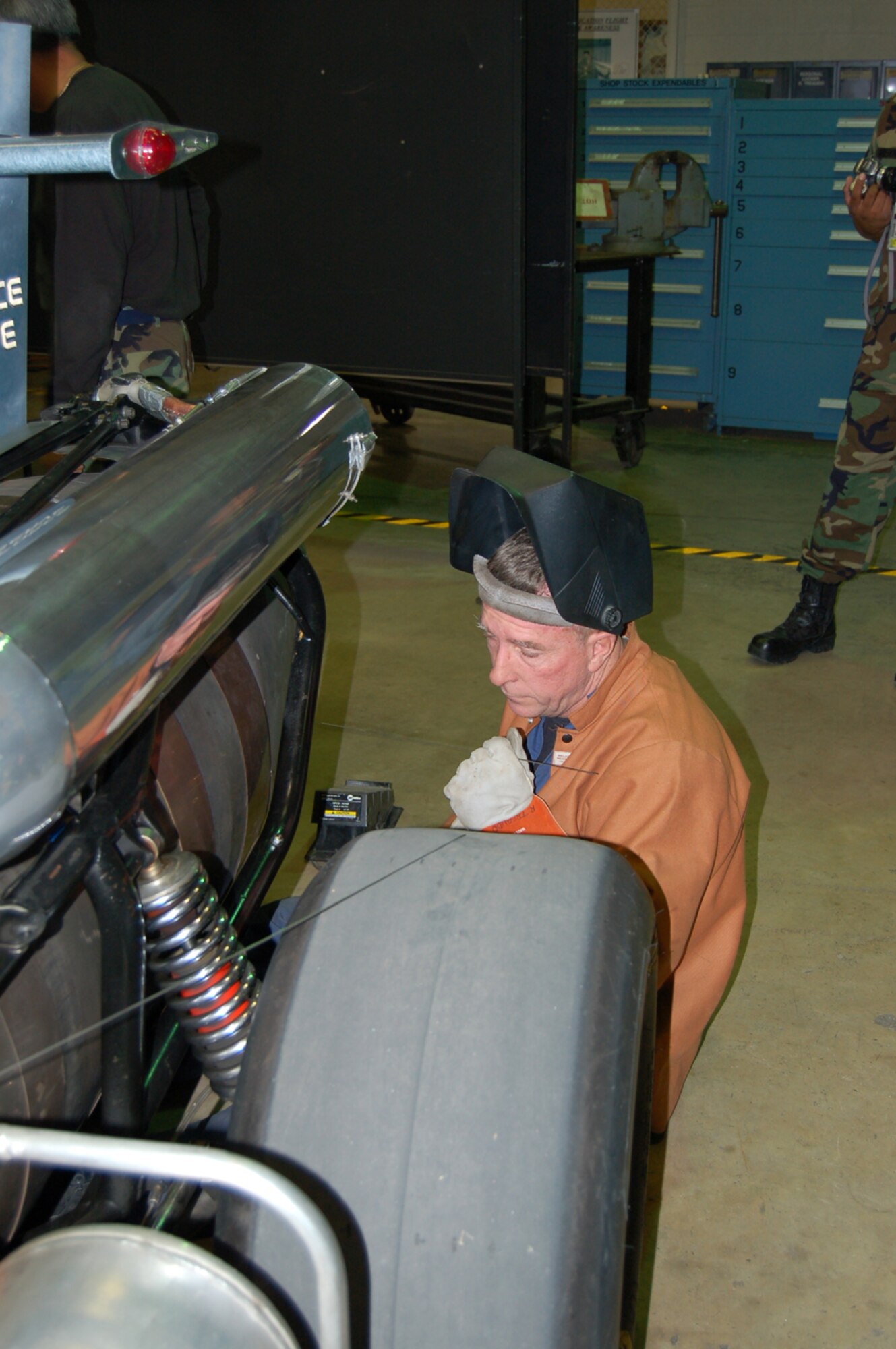 Tech. Sgt. Paul Zimmerschied, a welder with the 433rd Maintenance Group at Lackland AFB, preps the metal band around the canister of the Air Force Reserve jet car's exhaust. During Airfest 2006, two of the bands that strengthen the canister where the afterburner is ignited developed two tears. With the help of the 433rd MXG metal shop, the jet car was able to continue to perform on the second day. (U.S. Air Force Photo/Master Sergeant Collen McGee)