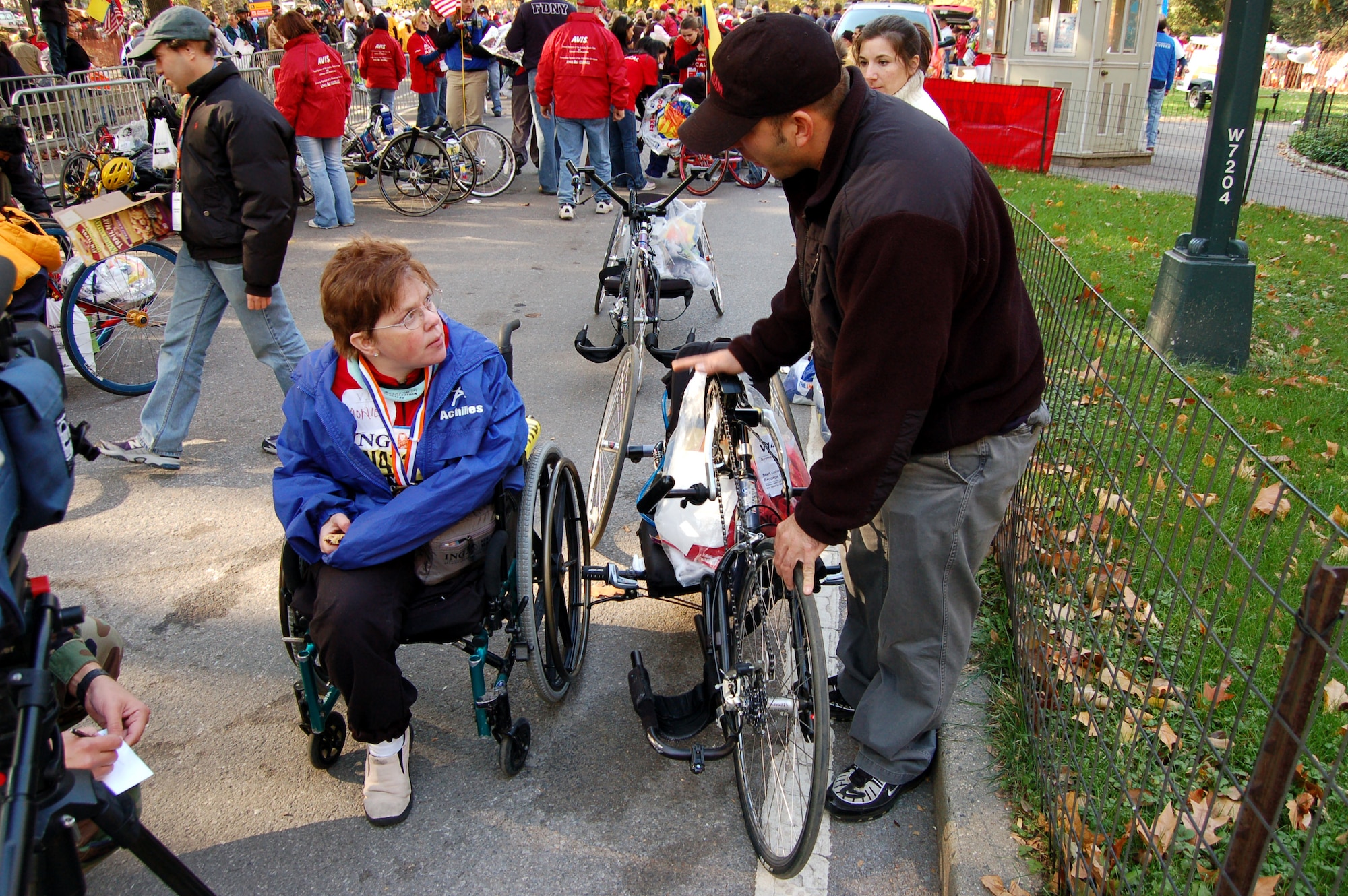 Achilles Freedom Team 'wounded warrior' Monica Szymanski gets help with her hand-crank cycle from New York Fire Department volunteers after she completed the New York City Marathon Nov. 5. The former Reserve senior airman, who lost her leg due to cancer, joined nearly 50 disabled veterans for the marathon. (U.S. Air Force photo/Staff Sgt. Shad Eidson)