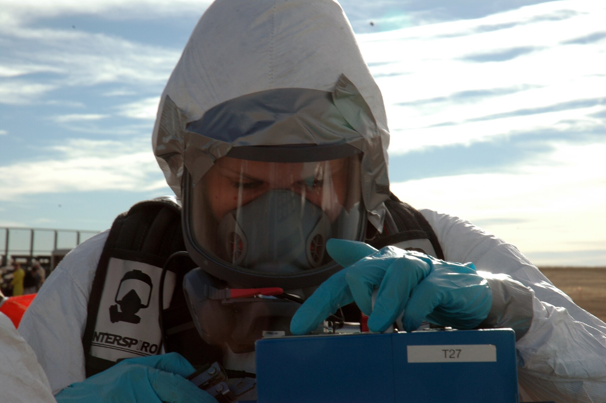 BUCKLEY AIR FORCE BASE, Colo. -- Senior Airman Jessica Mueller, 460th Medical Group Bioenvironmental Flight, programs the high volume air sampler, which samples airborne alpha radiation at the center of a contamination point during an exercise here Nov. 7. Members of the 460th Civil Engineer Squadron Emergency Management Flight, 460th Medical Group Bioenvironmental Flight and 460th CES Fire Protection Flight exercised their ability to move people from a contaminated area into an uncontaminated area through a decontamination line. (U.S. Air Force photo by Staff Sgt. Sanjay Allen)