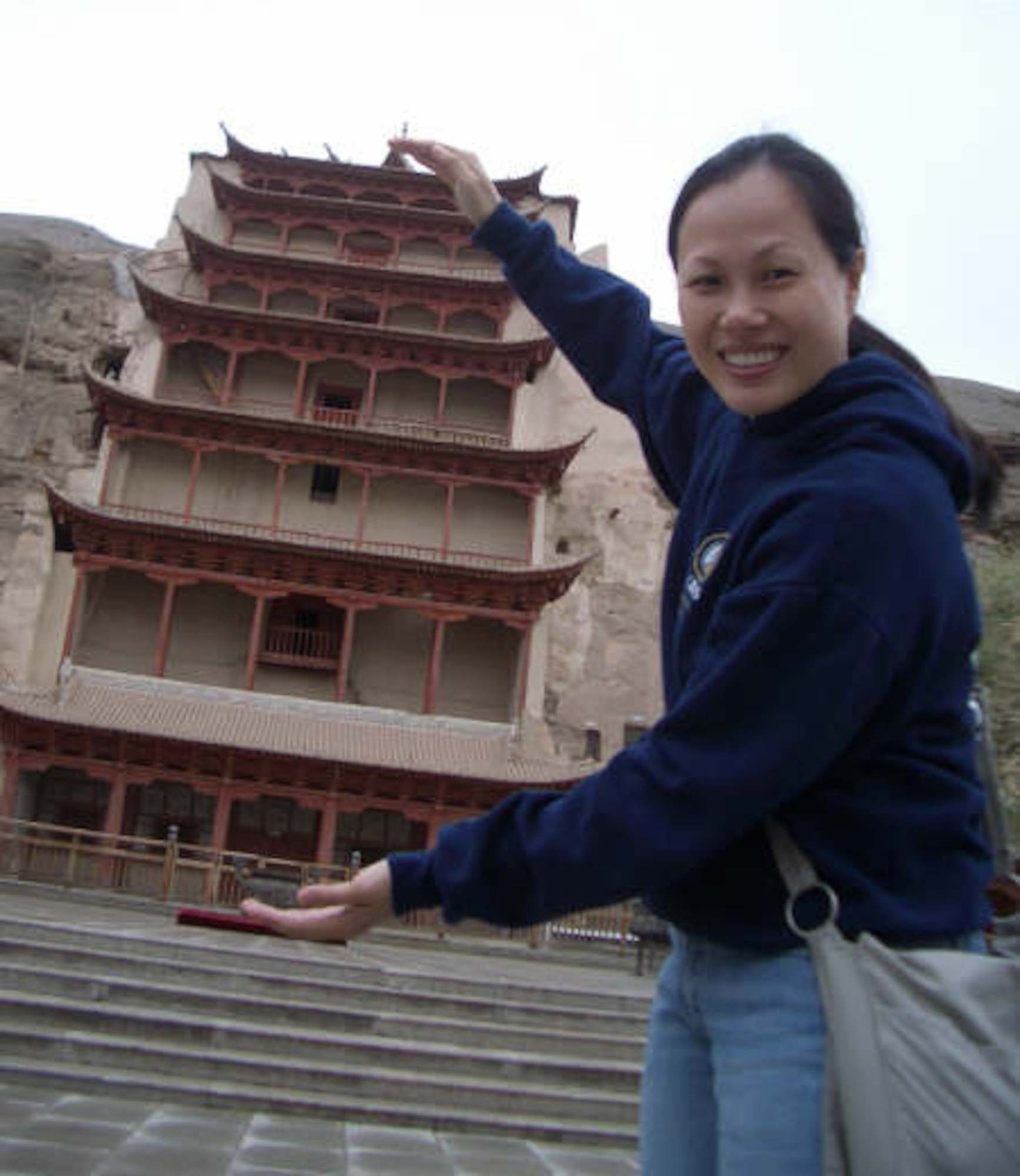 McCHORD AIR FORCE BASE, Wash., - Staff Sgt. Grace Qiu, 36th Aerial Port Squadron, tries to sqeeze this nine story high temple at MoGaoKu China. (Courtesy photo) 