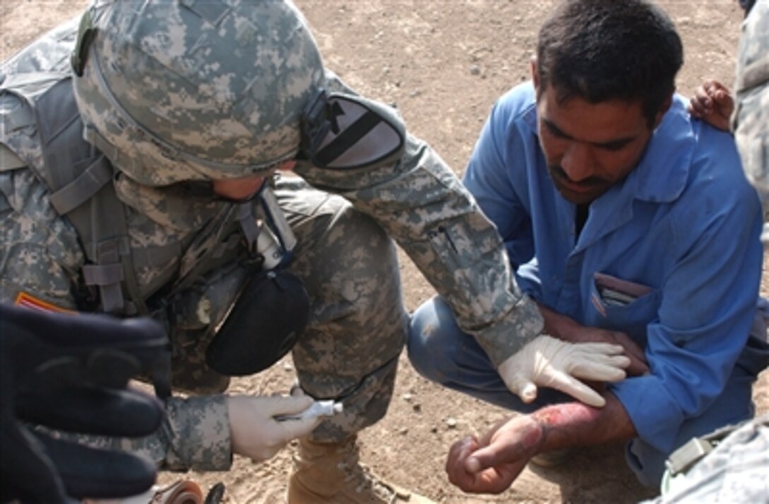 Army Spc. Jason Martin provides medical aid to an Iraqi man in Buhriz, Iraq, on Nov. 5, 2006. Martin and fellow soldiers assigned to Echo Company, 1st Battalion, 12th Cavalry Regiment, are in the region to report possible insurgent activity to the Iraqi army. 