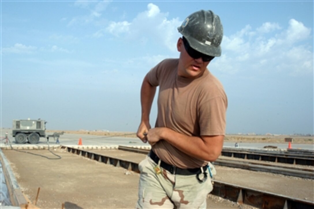 U.S. Navy Petty Officer 3rd Class Robert Ishum pulls out the winch line for a mechanic screed at Al Taqaddum Air Base, Iraq, Oct. 26, 2006. Ishum is assigned to Naval Mobile Construction Battalion 74, homeported in Gulfport, Miss. The sailors are repairing a runway at Al Taqaddum Air Base. 