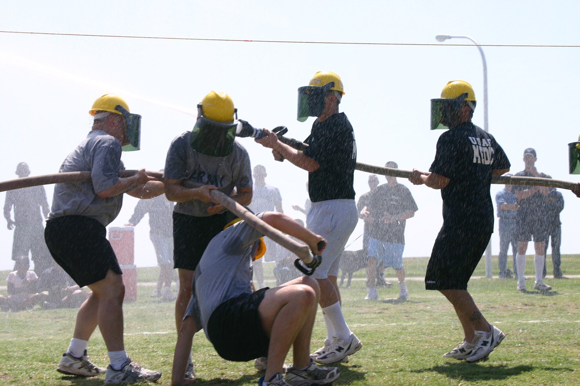 Members from the 383rd Training Squadron team face off against the Army service team in the fireman’s tug-of-war event. Both teams struggled to employ fire hoses to push the marker to the other teams side but the 383rd TRS won. (U.S. Air Force photo/Airman Jacob Corbin).