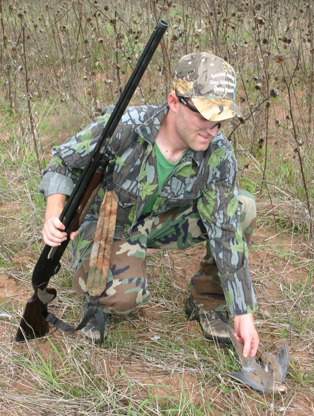 Adam Roberts, from the 80th Operations Support Squadron, retrieves a dove after a successful shot Saturday. (U.S. Air Force photo/Mike McKito)