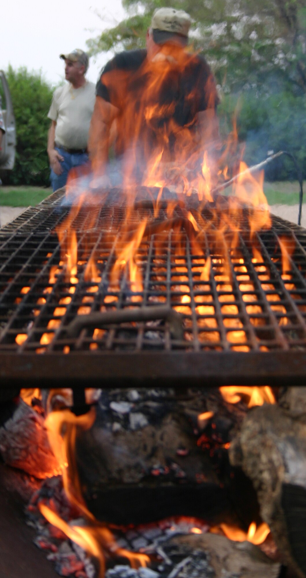 A rancher at  Saturday's Clay County military appreciation dove hunt checks the flames before cooking steaks for Team Sheppard members. Participants were not only treated to a free day of Dove hunting and skeet shooting, but received a steak dinner as well. (U.S. Air Force photo/Mike McKito)