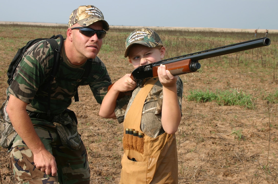 Robert Heis, from the 982nd Maitenance Squadron, watches as his daughter Elizabeth Heis takes aim Saturday at the second annual Clay County Dove Hunt Salute to the Military at the Birdwell and Clark Ranch in Henrietta, Texas. Participants were treated to dove hunting, skeet shooting and steak dinner, free of charge. (U.S. Air Force photo/Mike McKito)