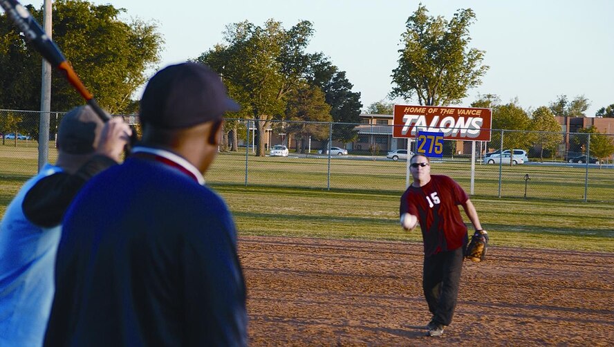 Off duty, Colonel Hill participates in squadron activities such as the softball team. Here he pitches during a Thursday night game.(Photo by Capt Tony Wickman)