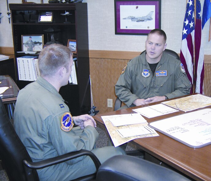 Capt. Luke Schneider, 25th Flying Training Squadron K-Flight commander, conducts a sortie pre-brief with Lt. Col. Nathan Hill, 25th FTS commander. Colonel Hill is responsible for more than 120 active-duty members, Reservists, students and a civilian, spread across four student flights, one check flight, one training flight and unit administration.(Photo by Capt Tony Wickman)