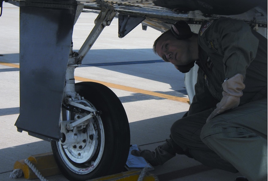 Instructor pilot 1st Lieutenant Philip McClure performs a pre-flight inspection prior to his training sortie. (Photo by Capt Tony Wickman)