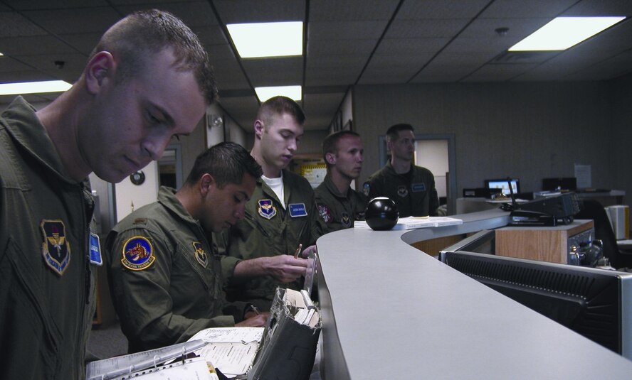 Student pilot 2nd Lt. Tim Lendrum, 2nd Lt. Omar Moreno, instructor pilot, Navy Ens. Jason Gordon, student pilot, and 1st Lt. Philip McClure, instructor pilot, receive final instructions and updated information from the operations desk prior to stepping to their T-37 aircraft.(Photo by Capt Tony Wickman)