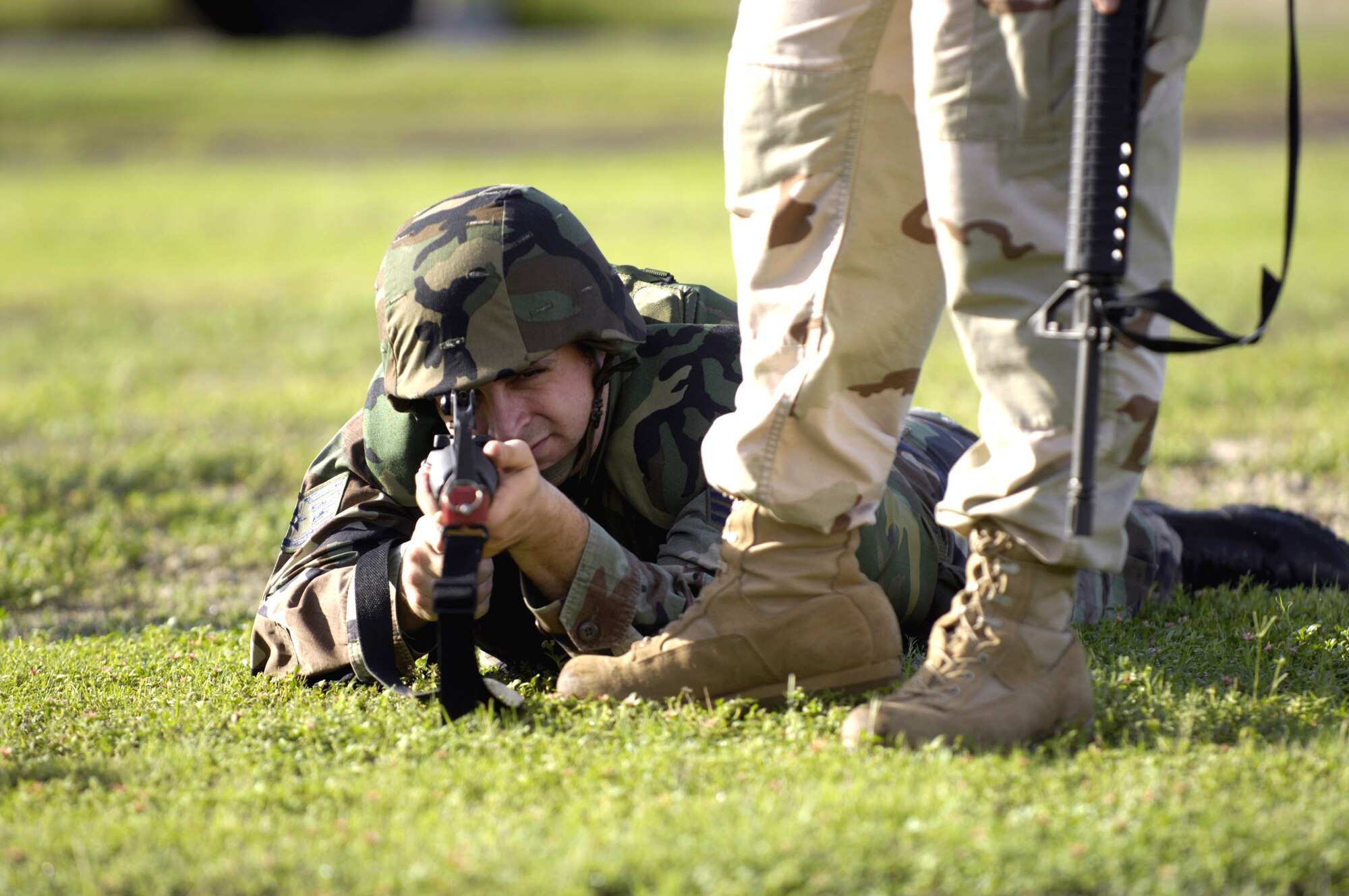 A student attending the Expeditionary Combat Skills Training Course Nov. 3 at Hickam Air Force Base, Hawaii, fires from the prone position during an individual movement techniques class as an instructor observes.  (U.S. Air Force photo/Tech. Sgt. Shane A. Cuomo) 