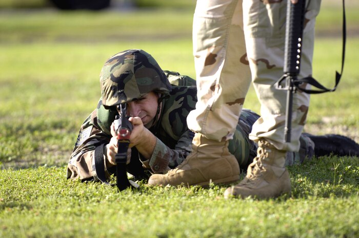 A student attending the Expeditionary Combat Skills Training Course Nov. 3 at Hickam Air Force Base, Hawaii, fires from the prone position during an individual movement techniques class as an instructor observes.  (U.S. Air Force photo/Tech. Sgt. Shane A. Cuomo) 